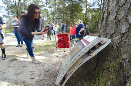 A fan takes a photo of the escape window of the plane at the monument site.
