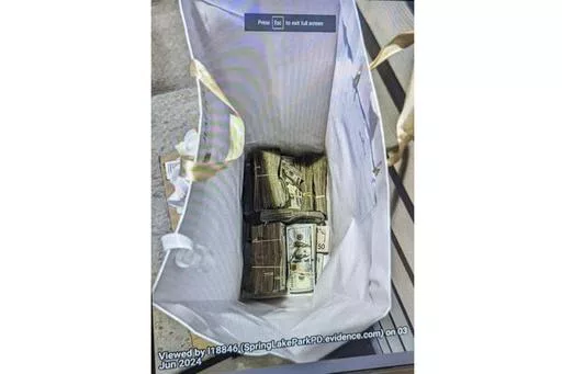 This photo supplied by the U.S. Attorney's Office for Minnesota shows cash from a bag that was left at the home of a juror in a massive fraud case, June 2, 2024, outside Minneapolis, Minn. Authorities have confiscated cellphones and taken all seven defendants into custody as investigators try to determine who attempted to bribe the juror to acquit them on charges of stealing more than $40 million from a program meant to feed children during the pandemic. (U.S. Attorney's Office for Minnesota via