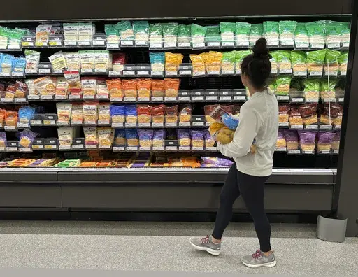 A shopper peruses cheese offerings at a Target store on Oct. 4, 2023, in Sheridan, Colo. Inflation is easing slightly, but grocery prices are still high. (AP Photo/David Zalubowski, File)