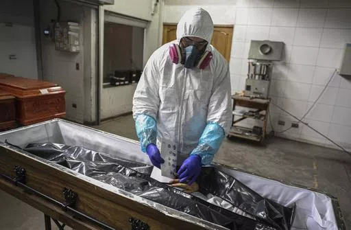 An employee takes the fingerprints of a woman who died from the new coronavirus before her remains are cremated at La Recoleta crematorium in Santiago, Chile, Saturday, June 27, 2020. Countries are still struggling to come up with an agreed-upon plan for how the world might respond to the next global outbreak. A ninth and final round of talks involving governments, advocacy groups and others to finalize a “pandemic treaty” is scheduled to end Friday, May 10, 2024. (AP Photo/Esteban Felix, Fi