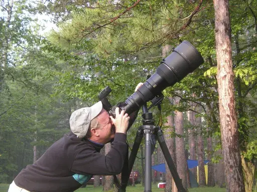 This May 2015, image provided by Doug Tallamy shows the University of Delaware entomologist and father of the modern native plants movement taking photos of warblers in Oxford, Pa. (Cindy Tallamy via AP)