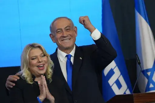 Former Israeli Prime Minister and the head of Likud party, Benjamin Netanyahu and his wife Sara gesture after first exit poll results for the Israeli Parliamentary election at his party's headquarters in Jerusalem, Wednesday, Nov. 2, 2022. (AP Photo/Tsafrir Abayov)