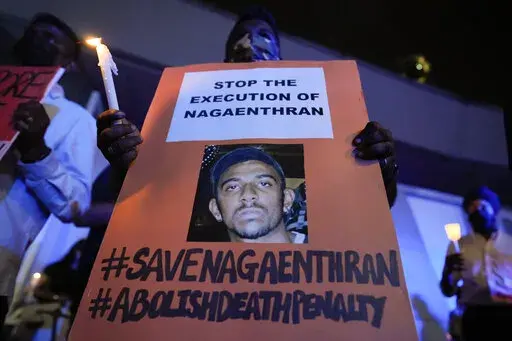 Activists hold posters against the impending execution of Nagaenthran K. Dharmalingam, sentenced to death for trafficking heroin into Singapore, during a candlelight vigil gathering outside the Singaporean Embassy in Kuala Lumpur, Malaysia, Tuesday, April 26, 2022. The Singapore Court of Appeal has dismissed a last-minute legal challenge filed by the mother of a mentally disabled Malaysian man in an attempt to halt his execution for drug trafficking. (AP Photo/Vincent Thian)