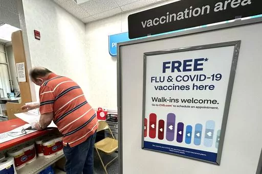A sign for flu and covid vaccinations is displayed at a pharmacy store in Palatine, Ill., Wednesday, Sept. 13, 2023. The flu season in the U.S. is getting worse but it's too soon to tell how much holiday gatherings contributed to a likely spike in illnesses. New government data posted Friday, Jan. 5, 2024 for the previous week _ the holiday week between Christmas and New Year's _ show 38 states with high or very high levels for respiratory illnesses with fever, cough and other symptoms. That's u