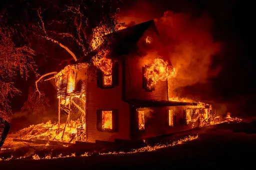 FILE - A home is engulfed in flames as the Dixie fire rages south of Janesville in Northern California, on Aug. 16, 2021. (AP Photo/Ethan Swope, File)