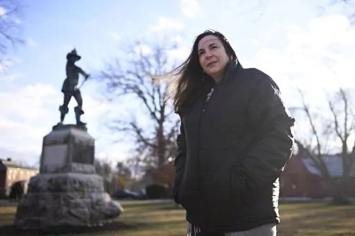 FILE — Beth Caruso, author and co-founder of the CT Witch Trial Exoneration Project, which was created to clear the names of the accused, stands on the Palisado Green in Windsor, Conn., Jan. 24, 2023. With distant family members looking on, Connecticut senators voted Thursday, May 25, 2023, to absolve the 12 women and men convicted of witchcraft -- 11 of whom were executed — more than 370 years ago and apologize for the “miscarriage of justice” that occurred over a dark 15-year-period of