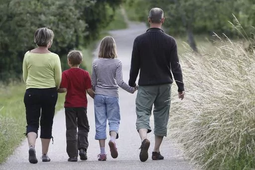 FILE -- This June 14, 2008 file photo shows a family walking through the fields in the village of Gaiberg, near Heidelberg, southwestern Germany. Germany’s justice minister has launched plans to relax the country’s strict restrictions on family names — for example, allowing couples to take double-barreled surnames and pass them on to their children. (AP Photo/Daniel Roland, file)