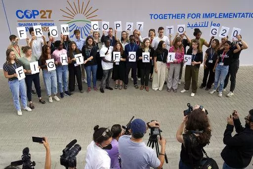 Youth climate activists hold signs that read "from COP27 to G20 fight for 1.5" at the COP27 U.N. Climate Summit, Monday, Nov. 14, 2022, in Sharm el-Sheikh, Egypt. (AP Photo/Peter Dejong)
