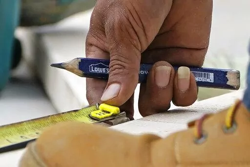 A workman aligns a plank before cutting it for use at a new housing site in Madison County, Miss., Tuesday, March 16, 2021. or anyone, Taking on a home renovation or even a simple repair project can turn disastrous — and expensive — without proper planning. When deciding whether to don safety glasses and get started or pay a professional, consider personal abilities, the time commitment and potential costs. (AP Photo/Rogelio V. Solis, File)