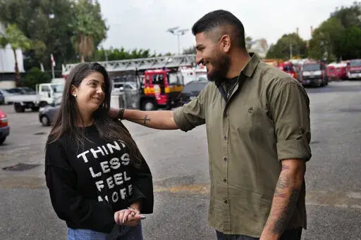 William Noun, right, whose brother Joe was a firefighter and killed during Beirut blast on Aug. 4, 2020, talks to his fiancee Maria Fares, left, whose sister Sahar was also a firefighter and killed in the same blast, at the firefighter headquarters, in Beirut, Lebanon, Wednesday, Dec. 14, 2022. It was a sad moment during which William Noun and Maria Fares met two years ago after their siblings were killed in Beirut's massive port blast. The couple got engaged this month and plan to get married n