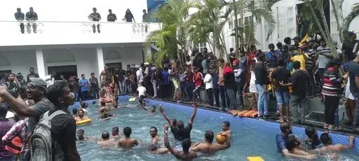 Anti government protesters swim in a swimmingpool of the Sri lankan president's official residence after storming into it in Colombo, Sri Lanka, Saturday, July 9, 2022. (AP Photo)