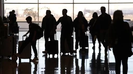 People pass through Salt Lake City International Airport Wednesday, Jan. 11, 2023, in Salt Lake City. Artificial intelligence chatbots like ChatGPT offer a novel way to research travel plans. They provide clear, easy-to-read suggestions that can be customized to almost any personal preference, leading to off-the-beaten-path suggestions that no guidebook or web search could provide. (AP Photo/Rick Bowmer, File)