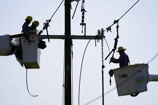 Crews work on power lines that were damaged in the aftermath of Hurricane Ida, Friday, Sept. 3, 2021, in LaPlace, La. (AP Photo/Matt Slocum)