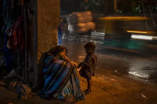 A homeless woman sits by the entrance to the a dilapidated shelter for homeless people in New Delhi, Dec. 30, 2022. The piercing chill is an ordeal for the city’s homeless, with New Delhi Sunday recording the minimum temperature of 5.5 degrees Celsius (41.9 Fahrenheit). New Delhi's 195 homeless shelters can accommodate only about 19,000 people, leaving tens of thousands struggling to keep warm. (AP Photo/Altaf Qadri)