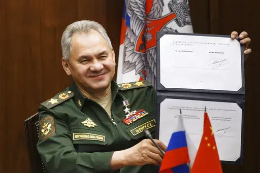 In this photo released by the Russian Defense Ministry Press Service, Russian Defense Minister Sergei Shoigu shows his signature under a roadmap for military cooperation between Russia and China during a video call with Chinese Defense Minister Wei Fenghe in Moscow, Russia, Tuesday, Nov. 23, 2021. The U.S. says Russia has asked China to provide military assistance for its war in Ukraine, and that China has responded affirmatively. Both Moscow and Beijing have denied the allegation, with a Chines