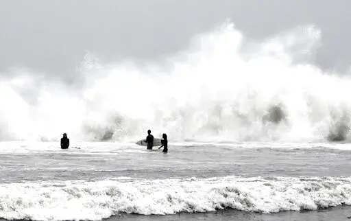 Surfers brave the waves during a rain storm at Venice Beach in Los Angeles on Saturday, Jan. 14, 2023. (Keith Birmingham/The Orange County Register via AP)
