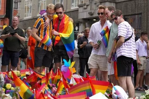 People react as they lay flowers at the scene of a shooting in central Oslo, Norway, Saturday, June 25, 2022. A gunman opened fire in Oslo’s night-life district early Saturday, killing two people and leaving more than 20 wounded in what Norwegian security service called an "Islamist terror act" during the capital’s annual Pride festival. (AP Photo/Sergei Grits)