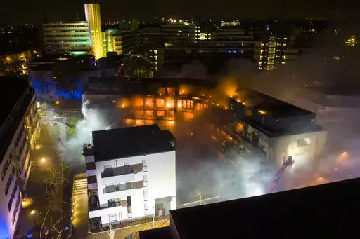 Firefighters battle a fire at residential complex in Essen Germany, Monday, Feb. 21, 2022. The fire service said that about 100 people were evacuated from the complex and about 150 officers were dispatched to fight the fire. (Stephan Witte/KDF-TV/dpa via AP)