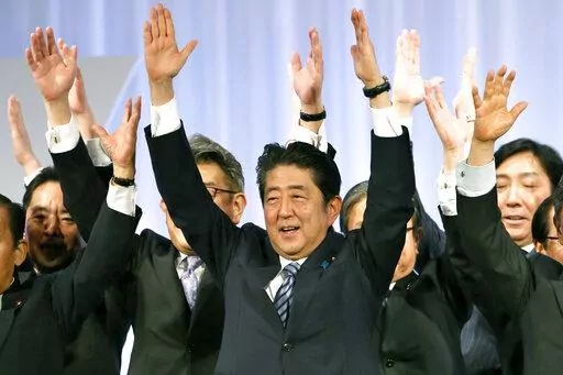 Japanese Prime Minister Shinzo Abe, center, shouts traditional "Banzai (long life)" cheers with lawmakers and members of his ruling Liberal Democratic (LDP) Party during its annual convention at a hotel in Tokyo on March 5, 2017. Assassinated former Prime Minister Shinzo Abe was perhaps the most divisive leader in recent Japanese history. He was also the longest serving and, by many estimations, the most influential. (AP Photo/Shizuo Kambayashi, File)
