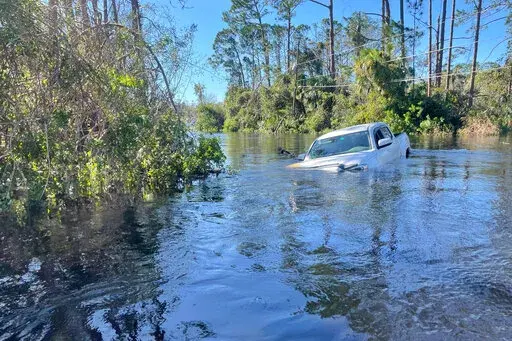 A car is submerged in flood water in North Port, Fla., on Friday, Sept. 30, 2022. (AP Photo/Adriana Gomez Licon)