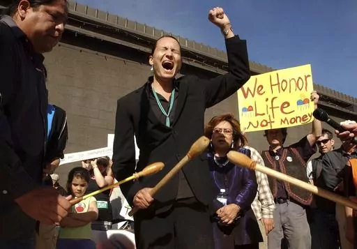 Klee Benally, a member of the Save the Peaks Coalition, sings an American Indian movement song, during a news conference held March 8, 2005, in Flagstaff, Ariz. Benally, a Navajo man who advocated on behalf of Indigenous people and environmental causes, has died Saturday, Dec. 30, 2023,, his sister said. (Jill Torrance/Arizona Daily Sun via AP, File)