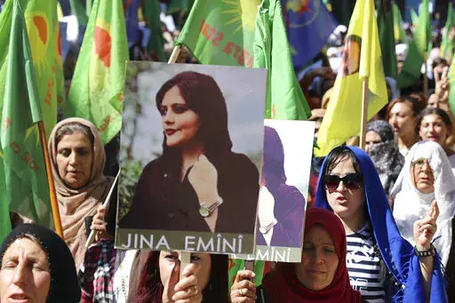 In this photo provided by Kurdish-run Hawar News Agency, Kurdish women hold portraits of Iranian Mahsa Amini, during a protest condemning her death in Iran, in the city of Qamishli, northern Syria, Monday, Sept. 26, 2022. Protests have erupted across Iran in recent days after Amini, a 22-year-old woman, died while being held by the Iranian morality police for violating the country's strictly enforced Islamic dress code. (Hawar News Agency via AP via AP)
