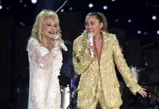 Dolly Parton, left, and Miley Cyrus perform "Jolene" at the 61st annual Grammy Awards in Los Angeles on Feb. 10, 2019. Administrators at Heyer Elementary School in Waukesha, Wis., aren't letting a first-grade class perform "Rainbowland," a Cyrus and Parton duet from Cyrus' 2017 album "Younger Now," promoting LGBTQ acceptance, because they say the song could be seen as controversial. (Photo by Matt Sayles/Invision/AP, File)