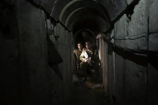 Israeli soldiers walk through a tunnel discovered near the Israel-Gaza border Sunday, Oct. 13, 2013. An extensive labyrinth of tunnels built by Hamas stretches across the dense neighborhoods of the Gaza Strip, hiding militants, their missile arsenal and the over 200 hostages they now hold after an unprecedented Oct. 7, 2023, attack on Israel. (AP Photo/Tsafrir Abayov, File)