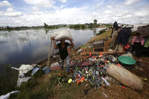 A man caries belongings from his house destroyed by tropical storm Ana in Antananarivo, Madagascar, Jan. 26, 2022. Extreme rainfall in Africa's southeast has become heavier and more likely to occur during cyclones because of climate change, according to a new analysis released Monday, April 11, 2022 by an international team of weather scientists. (AP Photo/Alexander Joe, file)