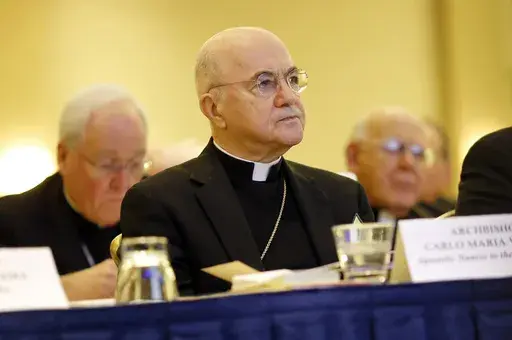 Archbishop Carlo Maria Vigano, Apostolic Nuncio to the U.S., listens to remarks at the U.S. Conference of Catholic Bishops' annual fall meeting in Baltimore, Nov. 16, 2015. The Vatican has excommunicated its former ambassador to the U.S., Archbishop Carlo Maria Viganò, after finding him guilty of schism, an inevitable end for the firebrand conservative who became one of Pope Francis' most ardent critics. (AP Photo/Patrick Semansky, File)