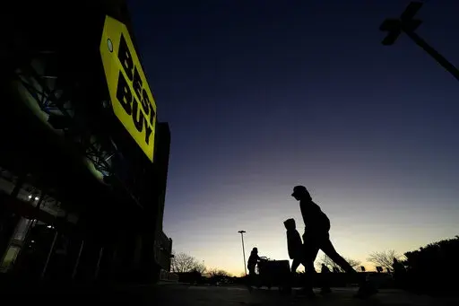 Shoppers are silhouetted against the sky as they arrives for a sale at a Best Buy store Friday, Nov. 25, 2022, in Overland Park, Kan. On Friday the Commerce Department issues its November report on consumer spending. The report contains a measure of inflation that is closely watched by the Federal Reserve, which has aggressively tried to corral inflation this year by raising its key lending rate seven times. (AP Photo/Charlie Riedel, File)