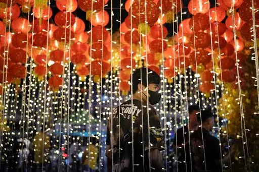 A man stands under lanterns during an event for the 430th anniversary of Manila's Chinatown, said to be the oldest in the world, at the capital's Binondo district, Philippines on Thursday, Feb. 1, 2024. Crowds are flocking to Manila's Chinatown to usher in the Year of the Wood Dragon and experience lively traditional dances on lantern-lit streets with food, lucky charms and prayers for good fortune. (AP Photo/Aaron Favila)
