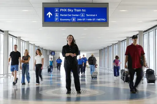Lindsay Ruck, a server at Phoenix Sky Harbor International Airport restaurants, pauses in Terminal 3 as she is anticipates the vote on Arizona Prop 138 on minimum wage Thursday, Oct. 3, 2024, in Phoenix. (AP Photo/Ross D. Franklin)