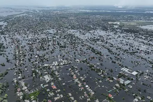 Houses are seen underwater in the flooded town of Oleshky, Ukraine, June 10, 2023. An AP investigation has found that Russian occupation authorities vastly and deliberately undercounted the dead in one of the most devastating chapters of the 22-month war in Ukraine - the flooding that followed the catastrophic explosion that destroyed the Kakhovka Dam in the southern Kherson region. (AP Photo/Evgeniy Maloletka, File)