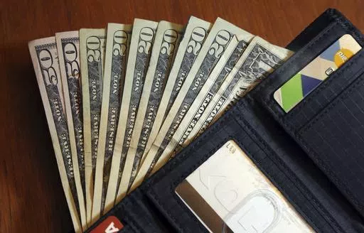 In this June 15, 2018, file photo, cash is fanned out from a wallet in North Andover, Mass. Conversations about money often require sensitivity and patience, especially when the person across the table is an older parent. Some of us won’t need — or want — to get involved in our parents’ finances. But others may have to take an active role in helping a parent manage their money. (AP Photo/Elise Amendola, File)