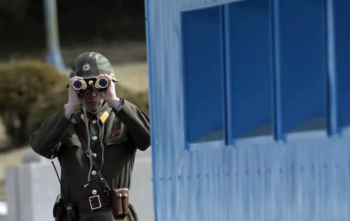 A North Korean soldier looks at the southern side through a pair of binoculars at the border village of the Panmunjom, in the Demilitarized Zone, DMZ, that separates the two Koreas since the Korean War, in Paju, north of Seoul, South Korea, Tuesday, March 19, 2013. A series of low-slung buildings and somber soldiers dot the landscape of the DMZ, the swath of land between North and South Korea where a soldier on a tour crossed into North Korea on Tuesday, July 18, 2023, under circumstances that r