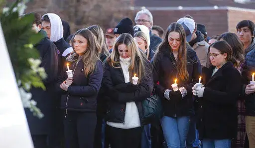 Boise State University students, along with people who knew the four University of Idaho students who were found killed in Moscow, Idaho, days earlier, pay their respects at a vigil held in front of a statue on the Boise State campus, Thursday, Nov. 17, 2022, in Boise, Idaho. Autopsies performed on the four students who were found dead inside a rental house near campus showed that all four were stabbed to death, the Latah County coroner said. (Sarah A. Miller/Idaho Statesman via AP)
