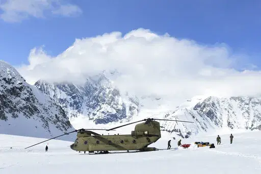 In this photo provided by the U.S. Army, soldiers and National Park Service personnel offload equipment and supplies from a CH-47 Chinook helicopter on Kahiltna Glacier, Alaska, on Wednesday, April 27, 2022. Those wishing to climb North America's tallest peak got a boost this week from the U.S. Army. Aviators from B Company, 1st Battalion, 52nd Aviation Regiment at Fort Wainwright flew two helicopters Wednesday to continue the decades-old tradition of helping set up base camp on Denali, a 20,310
