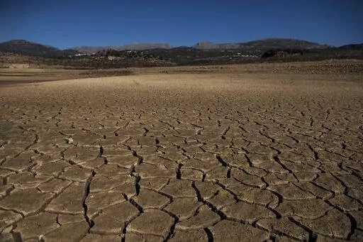 Part of the Vinuela reservoir is seen dry and cracked due to lack of rain in La Vinuela, southern Spain, Feb. 22, 2022. Declining agricultural yields in Europe, and the battle for diminishing water resources, especially in the southern part of the continent, are key risks as global temperatures continue to rise. These conclusions are part of a new United Nations report that will help countries decide how to prevent the planet from warming further. (AP Photo/Carlos Gil)