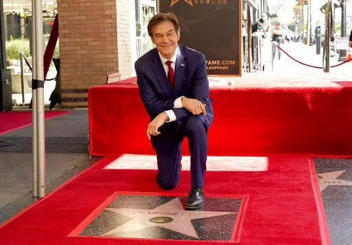Mehmet Oz, the former host of "The Dr. Oz Show," poses atop his new star on the Hollywood Walk of Fame during a ceremony on Feb. 11, 2022, in Los Angeles. Oz may have made his reputation as a surgeon. But he made a fortune as a salesman on daytime TV. Now he is trying to leverage his celebrity as the Republican candidate in a bitterly contested U.S. Senate race in Pennsylvania. (AP Photo/Chris Pizzello, File)
