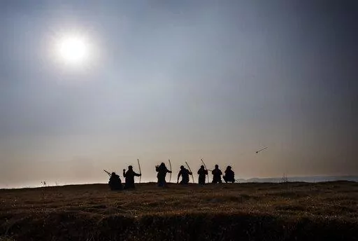 A group of local archers are silhouetted against the afternoon sun on a ridge overlooking the Laitlum Canyon about 20km (12 miles) from Shillong, India, Sunday, Jan. 22, 2023. In villages scattered across the northeastern Indian state of Meghalaya an ancient tradition of archery still continues and regular competitions are held between different localities. (AP Photo/Ashwini Bhatia)