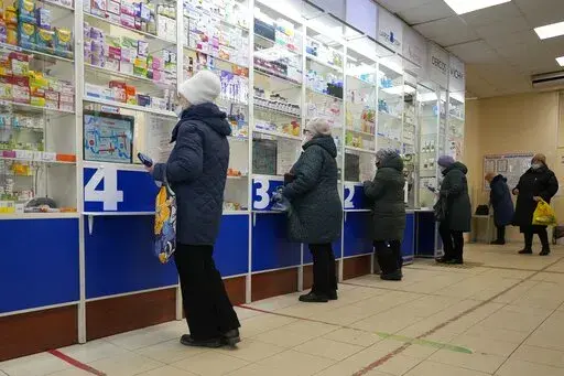 Customers stand at the windows buying medicines in a pharmacy in St. Petersburg, Russia, Friday, April 1, 2022. (AP Photo)