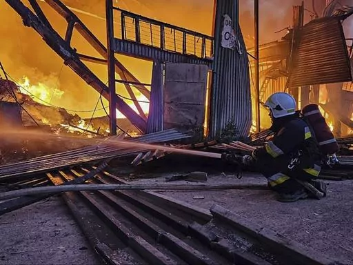 In this photo provided by the Ukrainian Emergency Service, emergency services personnel work to extinguish a fire following a Russian attack in Lviv, Ukraine, Tuesday, Sept. 19, 2023. (Ukrainian Emergency Service via AP)