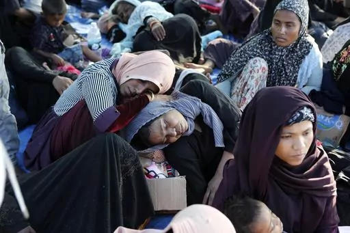 Ethnic Rohingya women rest under a tent after landing on a beach in Kuala Besar, North Sumatra, Indonesia, Sunday, Dec. 31, 2023. Dozens of likely Rohingya refugees, mostly hungry and weak women and children, were found on a beach in Indonesia's North Sumatra province after weeks at sea, officials said on Sunday. (AP Photo/Dedy Zulkifli)
