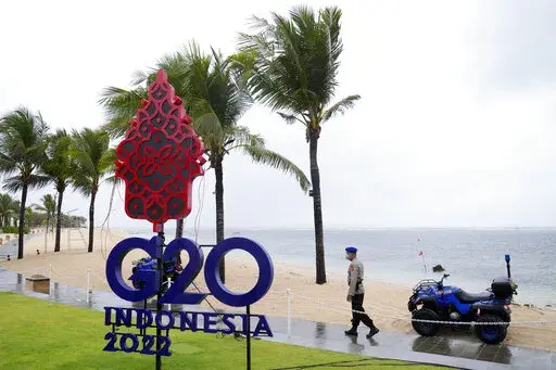 A police officer walks past a G20 sign in Nusa Dua, Bali, Indonesia, Thursday, July 7, 2022. Foreign ministers from the Group of 20 leading rich and developing nations are gathering in Indonesia's resort island of Bali for talks bound to be dominated by the conflict in Ukraine despite an agenda focused on global cooperation and food and energy security. (AP Photo/Dita Alangkara)