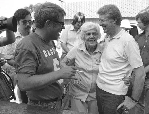 Lillian Carter is flanked by her sons Jimmy, right, and Billy as she met them down at Billy's gas station, where the Carters and neighbors cleaned fish prior to a town cookout, June 26, 1976. When Jimmy Carter stepped onto the national stage, he brought those closest to him along, introducing Americans to a colorful Georgia family that helped shape the 39th president’s public life and now, generations later, is rallying around him for the private final chapter of his 98 years. (AP Photo/Mark F