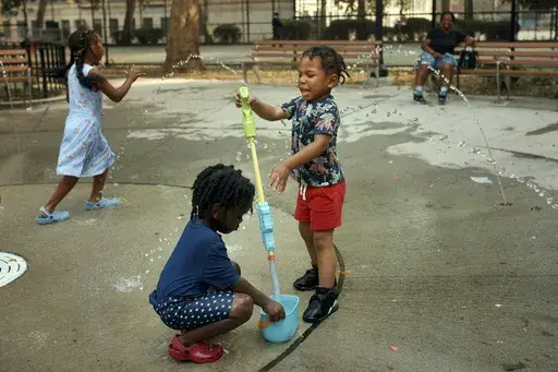 Children play in a water park on a hot day, Friday, June 21, 2024, in the Bronx Borough of New York. Tens of millions of Americans are facing major heat waves, with temperatures consistently exceeding 90 degrees (32 degrees Celsius). (AP Photo/Andres Kudacki)