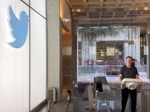 This image from the Twitter page of Elon Musk shows Musk entering Twitter headquarters carrying a sink through the lobby area on Wednesday, Oct. 26, 2022 in San Francisco.  Musk posted a video Wednesday showing him strolling into Twitter headquarters ahead of a Friday deadline to close his $44 billion deal to buy the company.  (Twitter page of Elon Musk via AP)