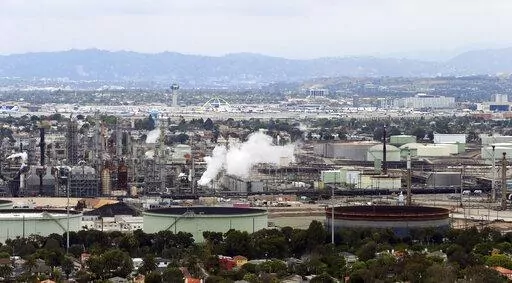 This aerial photo shows the Standard Oil Refinery in El Segundo, Calif., with Los Angeles International Airport in the background and the El Porto neighborhood of Manhattan Beach, Calif., in the foreground on May 25, 2017. California air regulators are set to approve an ambitious plan for the state to achieve carbon neutrality by 2045. Doing so will require a rapid transition away from oil and gas and toward renewable energy to power everything from cars to buildings. (AP Photo/Reed Saxon, File)