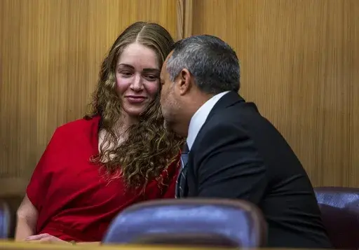 Defense attorney Frank Prieto talks with OnlyFans model Courtney Clenney in the courtroom during a hearing in front of Judge Laura Shearon Cruz, where the computer hacking charges against her and her parents, Deborah and Kim Clenney, were dismissed at the Gerstein Justice Building, Thursday, July 11, 2024, in Miami. Courtney Clenney is accused of stabbing to death her boyfriend in a Miami condo in 2022. The murder charge has not been dropped. (Pedro Portal/Miami Herald via AP)